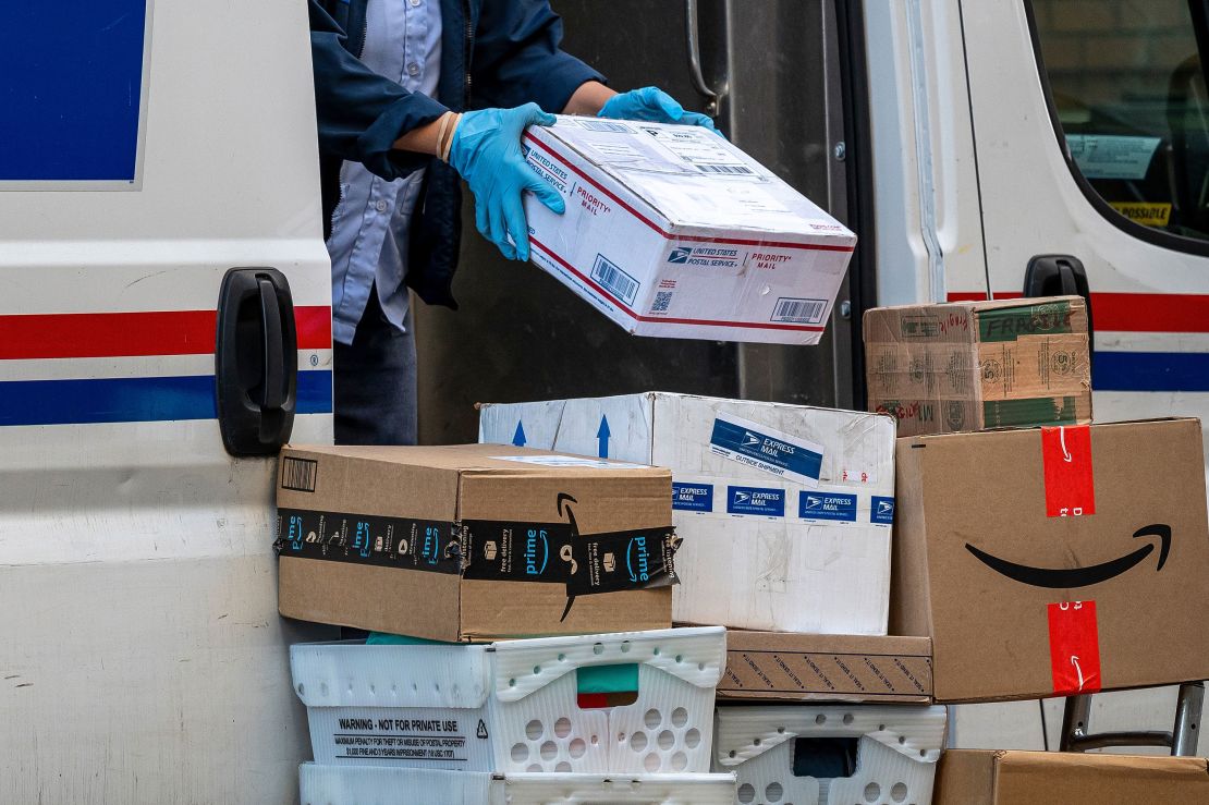 A United States Postal Service worker delivers packages in San Francisco on November 27, 2023.