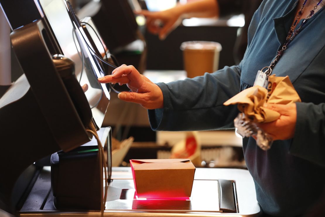 A customer uses a self checkout kiosk at Harmons Grocery store in Salt Lake City, Utah, U.S., on Thursday, Oct. 21, 2021.