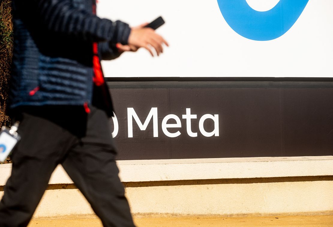 A person walks past a newly unveiled logo for 