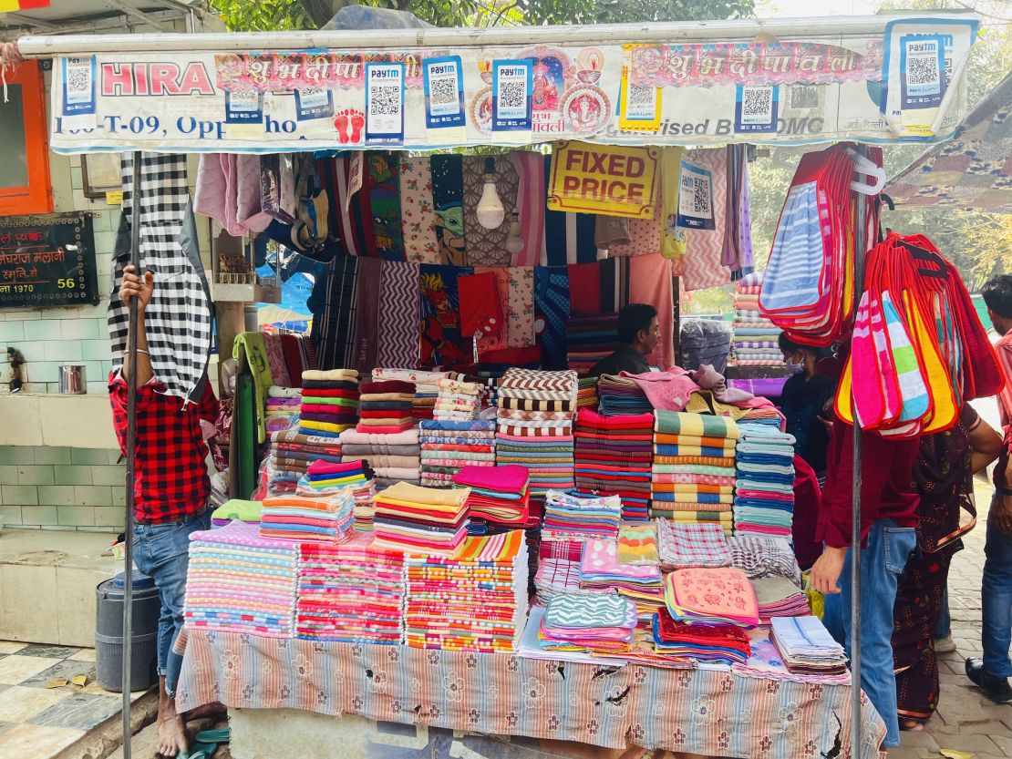 Black and white QR codes line the awning of Ramesh Kumar's towel shop in Sarojini Nagar Market in Delhi