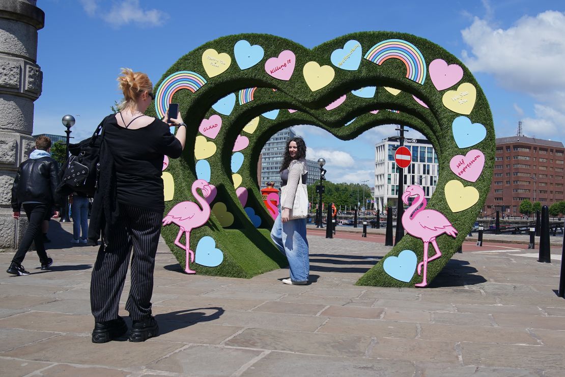 People pose for a photograph at the Lover album artwork which is part of the Taylor Town Trail, a Taylor Swift themed art trail through Liverpool based on her album eras, ahead of The Eras Tour concert at Anfield Stadium on Thursday. Picture date: Monday June 10, 2024. (Photo by Peter Byrne/PA Images via Getty Images)