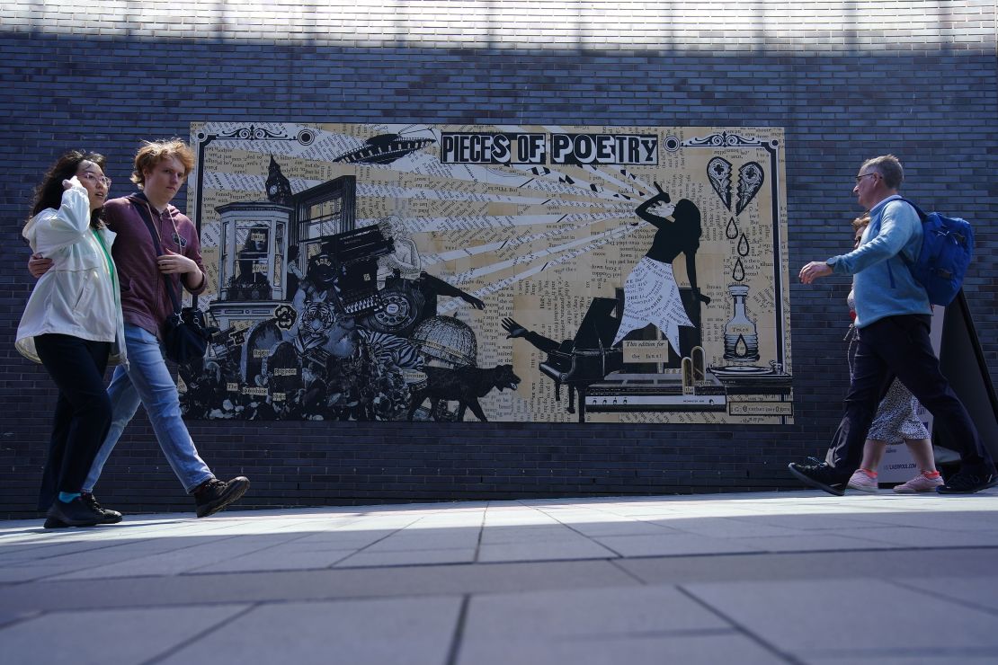 People walk past A The Tortured Poets Department artwork which is part of the Taylor Town Trail, a Taylor Swift themed art trail through Liverpool based on her album eras, ahead of The Eras Tour concert at Anfield Stadium on Thursday. Picture date: Monday June 10, 2024. (Photo by Peter Byrne/PA Images via Getty Images)