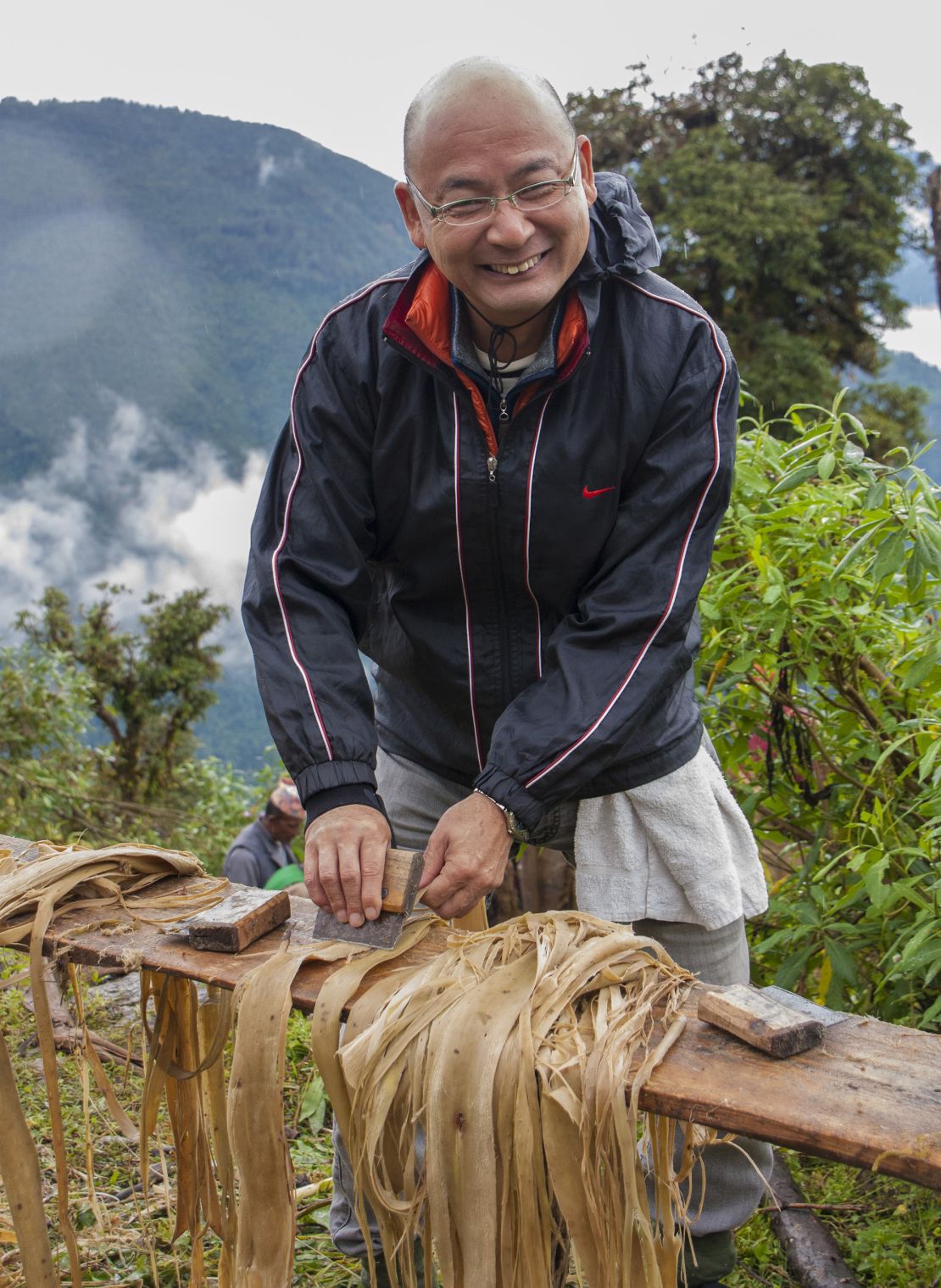 Tadashi Matsubara, the president of Kanpou, training farmers on processing paperbush bark in Ilam, Nepal in 2020.