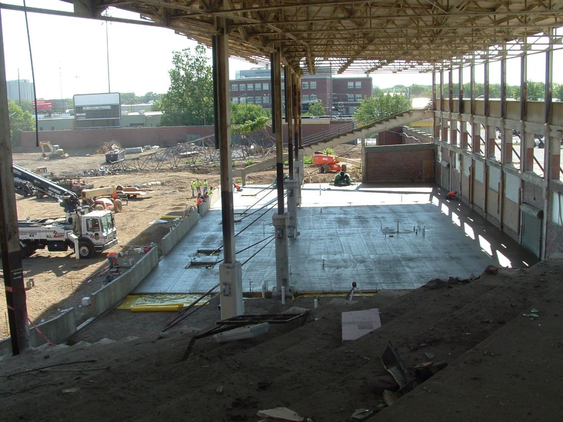 A construction photo was taken during the historic Bush Stadium's conversion into the Stadium Lofts apartment building. The photo depicts a new floor slab where the grandstands were removed as well as the retained historic roof, structure, and exterior wall.