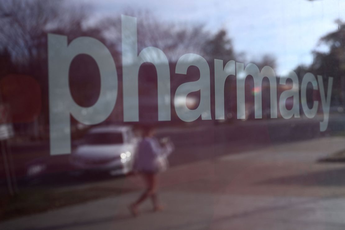 A pedestrian is reflected in the window of a CVS Pharmacy in Washington, DC, on November 2, 2022.